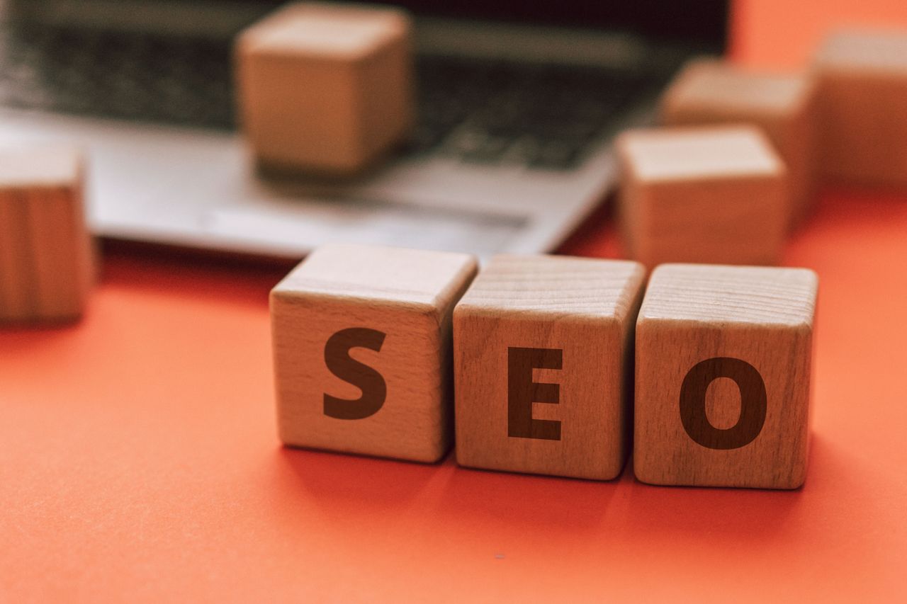 Des blocs en bois formant SEO sur le clavier d’un ordinateur portable illustrent des notions de marketing numérique.